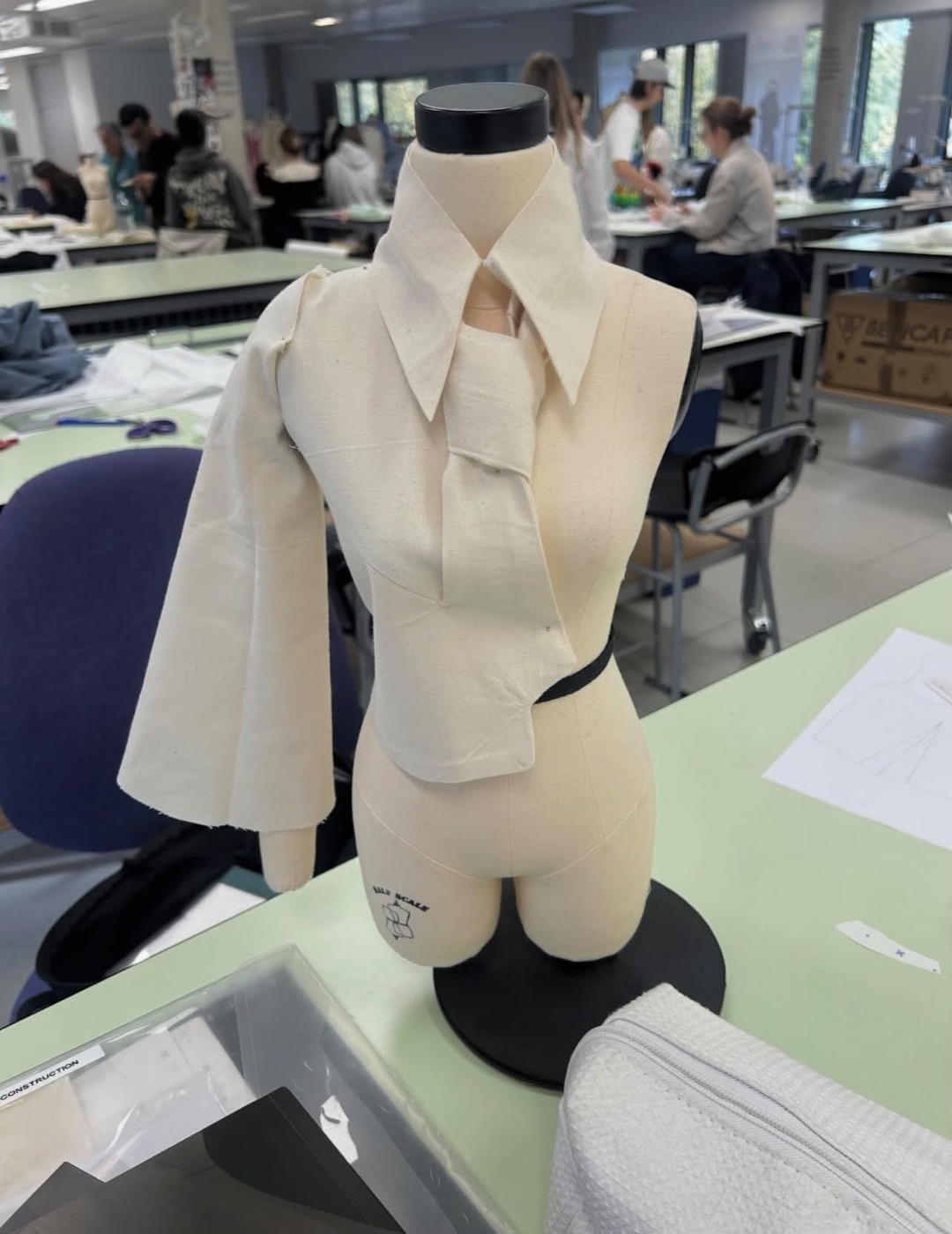 A calico toile of the shirt with a tie collar on a half-scale dress form